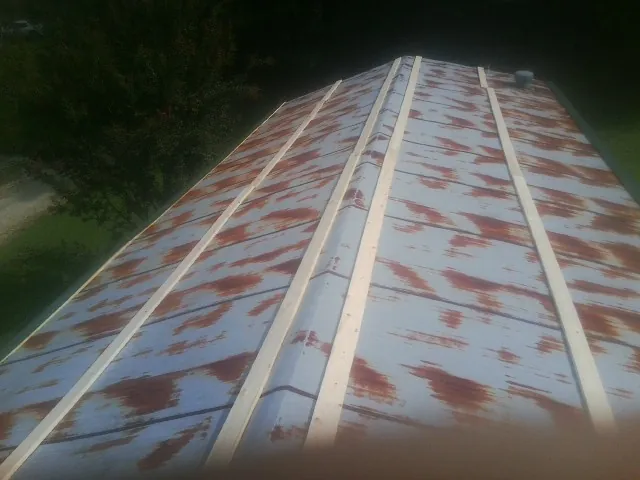 Rusted metal roof panels with new wood purlins before replacement — Storm Damage Roof Repair in Wheeler by Roofing Brothers